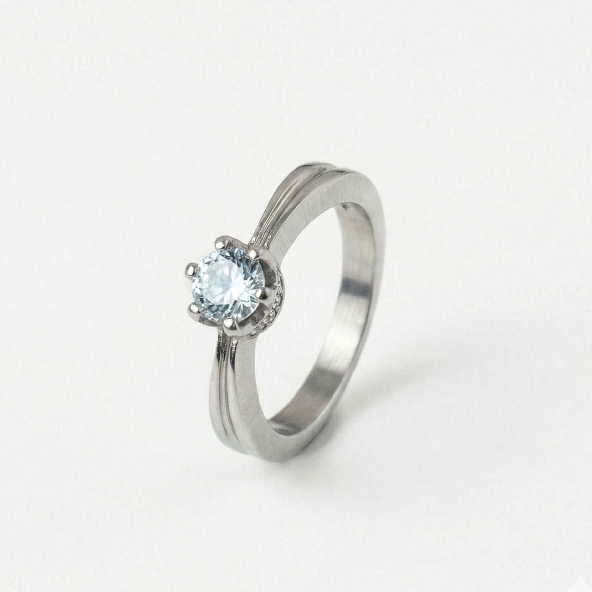 Anillo de compromiso en titanio enchapado en oro 18K de color plateado, sobre fondo blanco - producto de Joyería Monael