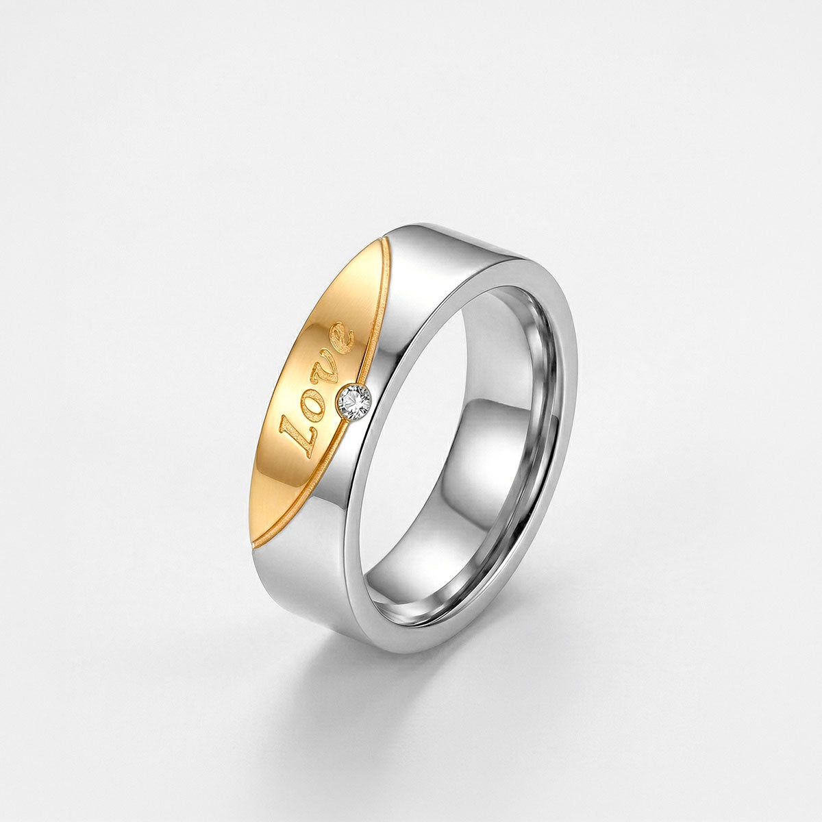 Anillo para dama bicolor de titanio enchapado en oro con grabado Love y piedra brillante central, fondo blanco - Codigo 5360