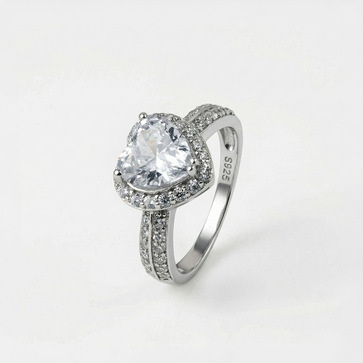 Anillo de compromiso de plata ley 925 con piedra en forma de corazón y pedrería alrededor, sobre fondo blanco - producto de Joyería Monael