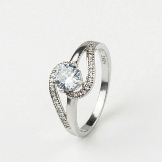 Anillo de compromiso de plata ley 925 con diseño curvo con pedrerías incrustadas, sobre fondo blanco - producto de Joyería Monael
