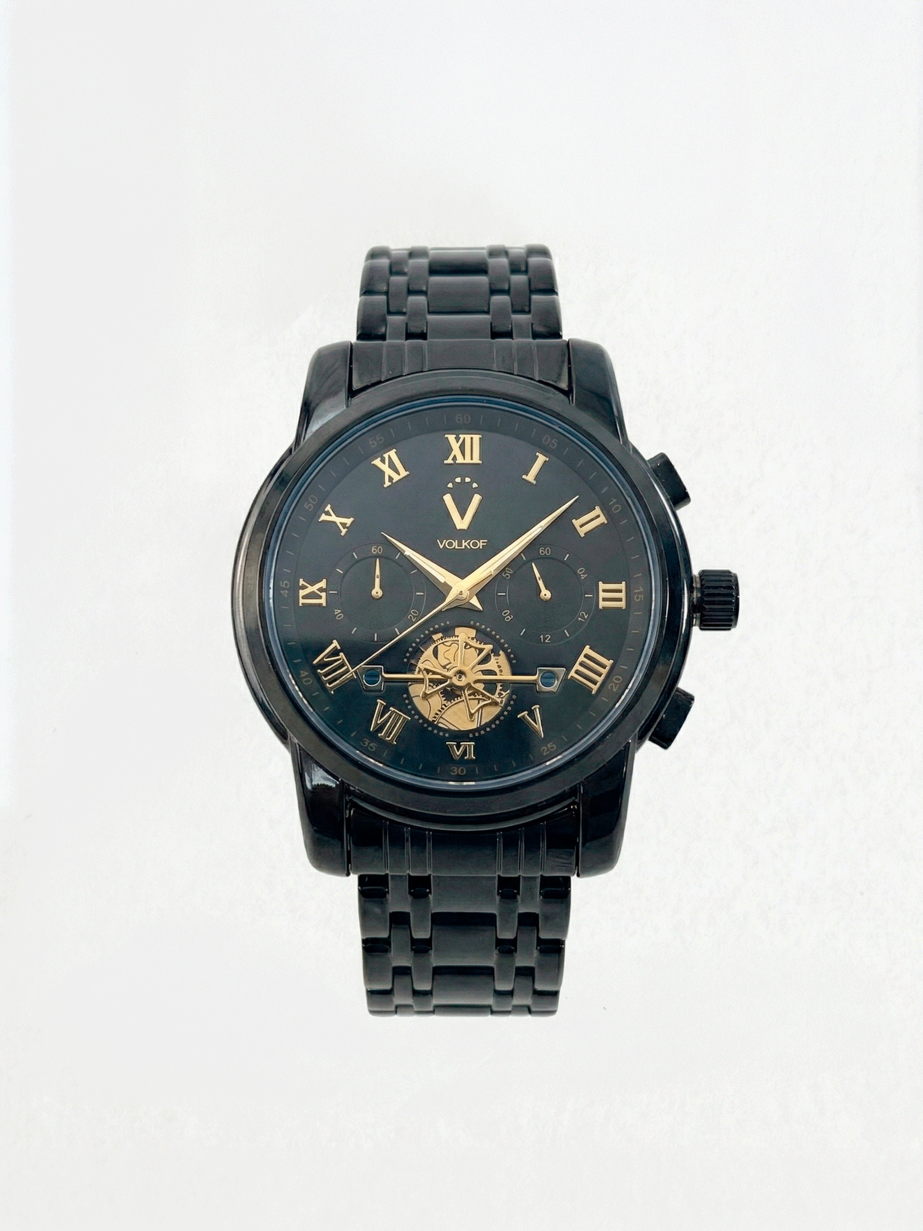 Reloj analógico para hombre en acero inoxidable color negro, esfera oscura con números romanos dorados, subesferas decorativas y ventana inferior con mecanismo dorado visible, caja de 42mm